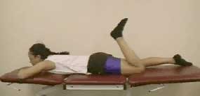 Patient lying on tummy and flexing one leg.