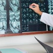 Photograph of a surgeon explaining an MRI scan to a patient.