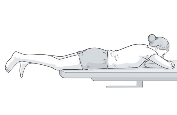 Illustration of patient lying face down with the legs hanging over the end of the plinth.